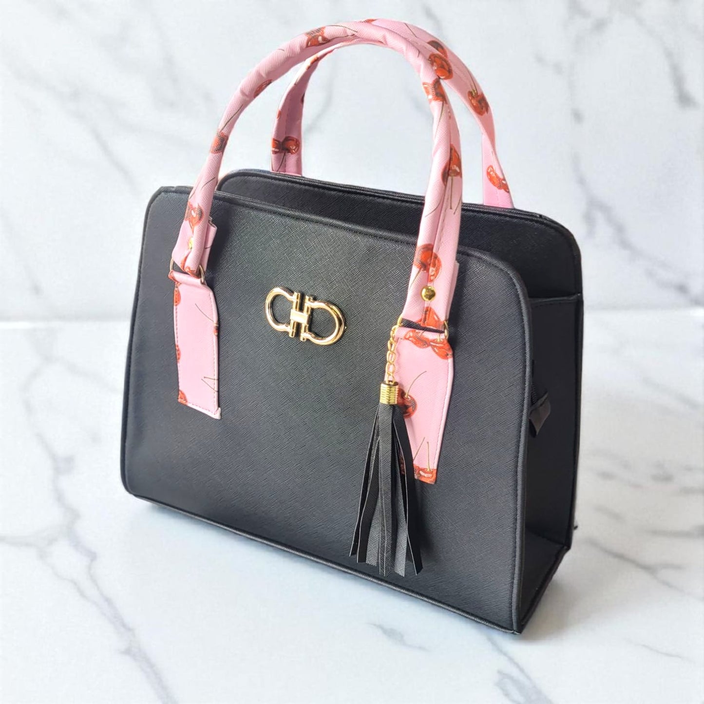 Bolso de mano elegante negro con asas forradas en pañuelo rosa y borla decorativa
